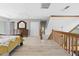 Open bedroom with stairs, light wood floors, dresser, closet, and views at 6633 Driftwood Dr, Hudson, FL 34667