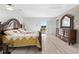 Bedroom with decorative wood bed frame, dresser and mirror, plus sliding doors to a balcony at 6633 Driftwood Dr, Hudson, FL 34667