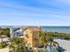 Multi-story home featuring a balcony and palm trees, with a beautiful waterfront view on a sunny day at 6633 Driftwood Dr, Hudson, FL 34667