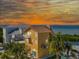 Charming multi-story home with a balcony, palm trees, and a picturesque waterfront view at sunset at 6633 Driftwood Dr, Hudson, FL 34667