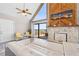 Bright living room features a wood accent wall with marble fireplace and sliding doors to deck at 6633 Driftwood Dr, Hudson, FL 34667