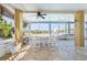 Enclosed patio featuring tile floors, ceiling fan, and seating overlooking water views at 6633 Driftwood Dr, Hudson, FL 34667