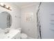 Bright bathroom with a mirror, a toilet, a sink, and a shower behind a patterned curtain at 6712 W Clifton St, Tampa, FL 33634