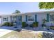 Charming home featuring a light-gray brick exterior with striking blue shutters and a beautifully landscaped front yard at 6712 W Clifton St, Tampa, FL 33634