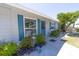 Charming home featuring a light-gray brick exterior with striking blue shutters and a beautifully landscaped front yard at 6712 W Clifton St, Tampa, FL 33634