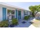 Charming home featuring a light-gray brick exterior with striking blue shutters and a beautifully landscaped front yard at 6712 W Clifton St, Tampa, FL 33634