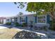 Charming home featuring a light-gray brick exterior with striking blue shutters and a beautifully landscaped front yard at 6712 W Clifton St, Tampa, FL 33634