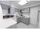 Well-lit kitchen featuring modern gray cabinets, white countertops, and stainless steel appliances for a sleek, updated look at 6712 W Clifton St, Tampa, FL 33634