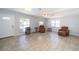 Spacious living room with neutral tile flooring, bright natural light, and ample space for seating arrangements at 6712 W Clifton St, Tampa, FL 33634