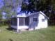 Quaint single-story home with a screened porch nestled among mature trees in a spacious yard at 710 E 129Th Ave, Tampa, FL 33612