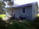Back exterior view of the home showing siding and access door at 710 E 129Th Ave, Tampa, FL 33612