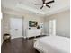 Bright main bedroom featuring a ceiling fan, tray ceiling, dark hardwood floors and a white dresser with TV at 7506 Sea Lilly Ct, Apollo Beach, FL 33572