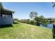 The landscaped backyard offers serene water views, blending seamlessly with the lush greenery, perfect for relaxation at 819 Birdie Way, Apollo Beach, FL 33572