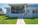 Inviting backyard with a screened-in lanai, and steps leading down to a brick path at 819 Birdie Way, Apollo Beach, FL 33572