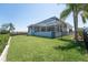 Expansive backyard featuring a screened-in lanai, lush lawn, and partial fencing with waterfront views at 819 Birdie Way, Apollo Beach, FL 33572