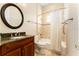 Bathroom with a granite countertop, wood vanity, and a shower-tub combo at 819 Birdie Way, Apollo Beach, FL 33572