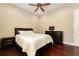 Bedroom with dark wood floors, ceiling fan, and a matching dresser at 819 Birdie Way, Apollo Beach, FL 33572