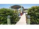Wooden dock with a covered boat lift, surrounded by green bushes, on a sunny day at 819 Birdie Way, Apollo Beach, FL 33572