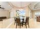 A well-lit dining area features a glass table, seating for six, and views of the pool area at 819 Birdie Way, Apollo Beach, FL 33572