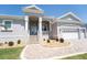 Charming home entrance featuring elegant columns, a brick pathway, and manicured landscaping at 819 Birdie Way, Apollo Beach, FL 33572