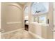 A entryway shows the tray ceilings, bedroom with hard wood floors, and the bright living room at 819 Birdie Way, Apollo Beach, FL 33572