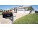 Inviting curb appeal with lush landscaping, a brick driveway, and a meticulously maintained lawn at 819 Birdie Way, Apollo Beach, FL 33572