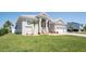 Well-maintained home featuring a lush green lawn, a brick driveway, and a two-car garage at 819 Birdie Way, Apollo Beach, FL 33572