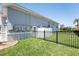 Side yard featuring a well-maintained lawn, utilities, and black fencing, providing a secure and private outdoor space at 819 Birdie Way, Apollo Beach, FL 33572