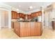 Spacious kitchen boasts wood cabinets, granite counters, stainless appliances, and an island with seating at 819 Birdie Way, Apollo Beach, FL 33572