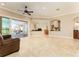 Spacious living room with tile floors, neutral tones, and seamless access to outdoor pool area at 819 Birdie Way, Apollo Beach, FL 33572
