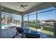Screened patio with calming water views features lounge seating and a ceiling fan for the ultimate outdoor living experience at 819 Birdie Way, Apollo Beach, FL 33572