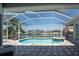 Screened-in pool featuring an attached spa and waterfront views, ideal for relaxation and entertaining at 819 Birdie Way, Apollo Beach, FL 33572