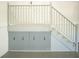 Staircase featuring wooden railings and storage cabinets underneath, offering both functionality and classic design at 819 Birdie Way, Apollo Beach, FL 33572