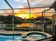 Tranquil sunset view over the water from the screened lanai, showcasing the beauty of the neighborhood at 819 Birdie Way, Apollo Beach, FL 33572