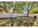 Serene backyard showcasing a white privacy fence, mature trees, and ample space for outdoor enjoyment at 8528 Quarter Horse Dr, Riverview, FL 33578