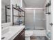 Bright bathroom features a sink, toilet, tub, and shelving unit for storage at 8528 Quarter Horse Dr, Riverview, FL 33578