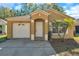 Cozy single-story home with a one-car garage, an arched doorway, and manicured landscaping at 8528 Quarter Horse Dr, Riverview, FL 33578