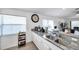 Bright kitchen featuring white cabinets, granite countertops, and modern appliances at 8528 Quarter Horse Dr, Riverview, FL 33578