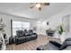 Cozy living room showcasing plank floors, fan, seating and a stylish fireplace at 8528 Quarter Horse Dr, Riverview, FL 33578