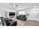 Bright living room featuring plank floors, fan, tv, shelving and comfortable leather seating at 8528 Quarter Horse Dr, Riverview, FL 33578