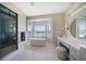 Relax in this luxurious bathroom with a soaking tub, walk-in shower, and plenty of natural light at 8685 E Bay Dr, Treasure Island, FL 33706