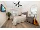 Cozy bedroom with wood-look floors, a ceiling fan, and a window with natural light at 8685 E Bay Dr, Treasure Island, FL 33706