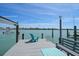 Inviting dock featuring a relaxing blue chair and bench, perfect for enjoying waterfront views on a sunny day at 8685 E Bay Dr, Treasure Island, FL 33706