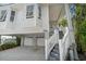 Beautiful exterior of the elevated home features a two car garage and landscaped entryway at 8685 E Bay Dr, Treasure Island, FL 33706