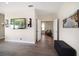 Hallway featuring gray wood floors, wall sconces, and an open door to another room at 8685 E Bay Dr, Treasure Island, FL 33706