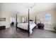 Spacious main bedroom with a king-sized bed, wood floors, ceiling fans, and a view of the water at 8685 E Bay Dr, Treasure Island, FL 33706