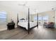 A spacious bedroom with hardwood floors, a four-poster bed, and water views at 8685 E Bay Dr, Treasure Island, FL 33706