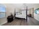 Spacious bedroom with hardwood floors, a four-poster bed, and balcony access with beautiful water views at 8685 E Bay Dr, Treasure Island, FL 33706