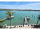 Scenic view of a waterfront backyard with a boat dock and lush landscaping at 8685 E Bay Dr, Treasure Island, FL 33706