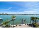 Breathtaking view of the waterfront featuring tropical landscaping, a private dock, and stunning water views at 8685 E Bay Dr, Treasure Island, FL 33706